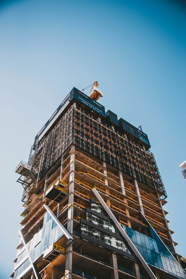 Brick and masonry building under construction with a worker at the upper level